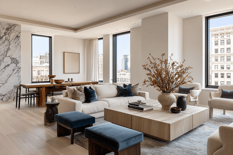 Luxury NYC loft living room with bouclé sofa, walnut coffee table, and floor-to-ceiling windows styled by a full-service interior design firm.