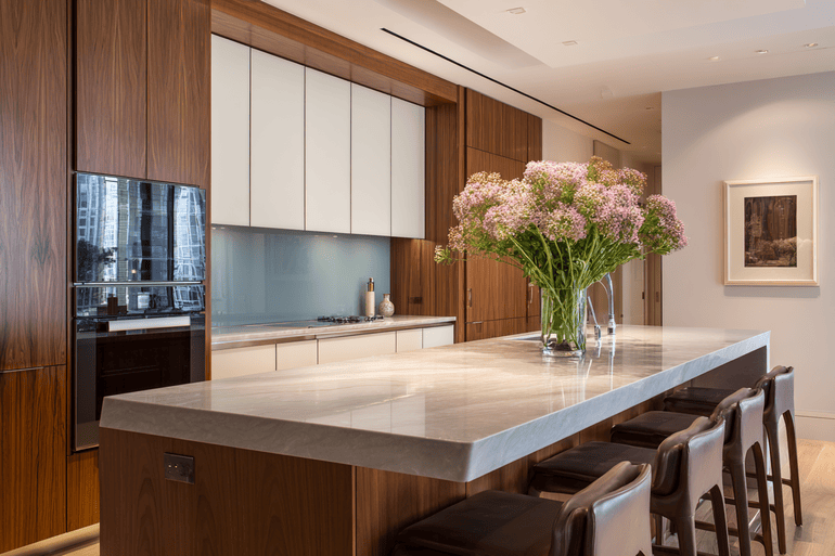 Curated stone and hardware selections arranged on a marble kitchen island in a luxury NYC loft