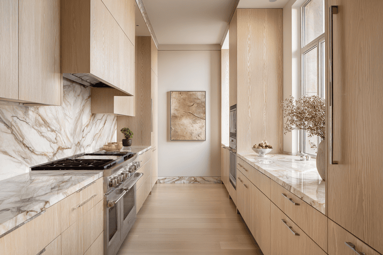 High-end NYC kitchen with white oak cabinetry, marble island, and terracotta vase accent.